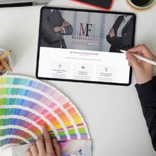 Eine Farbpalette und ein Tablet, das die Webseite von MFH Rechtsanwälte zeigt.