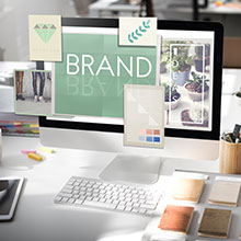 Desktop Arbeitsplatz mit Schriftzug "Brand" für unsere Leistungen im Markenrecht.