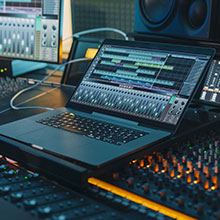 Notebook mit Musikprogramm im Musikstudio für unsere Leistungen im Medienrecht.